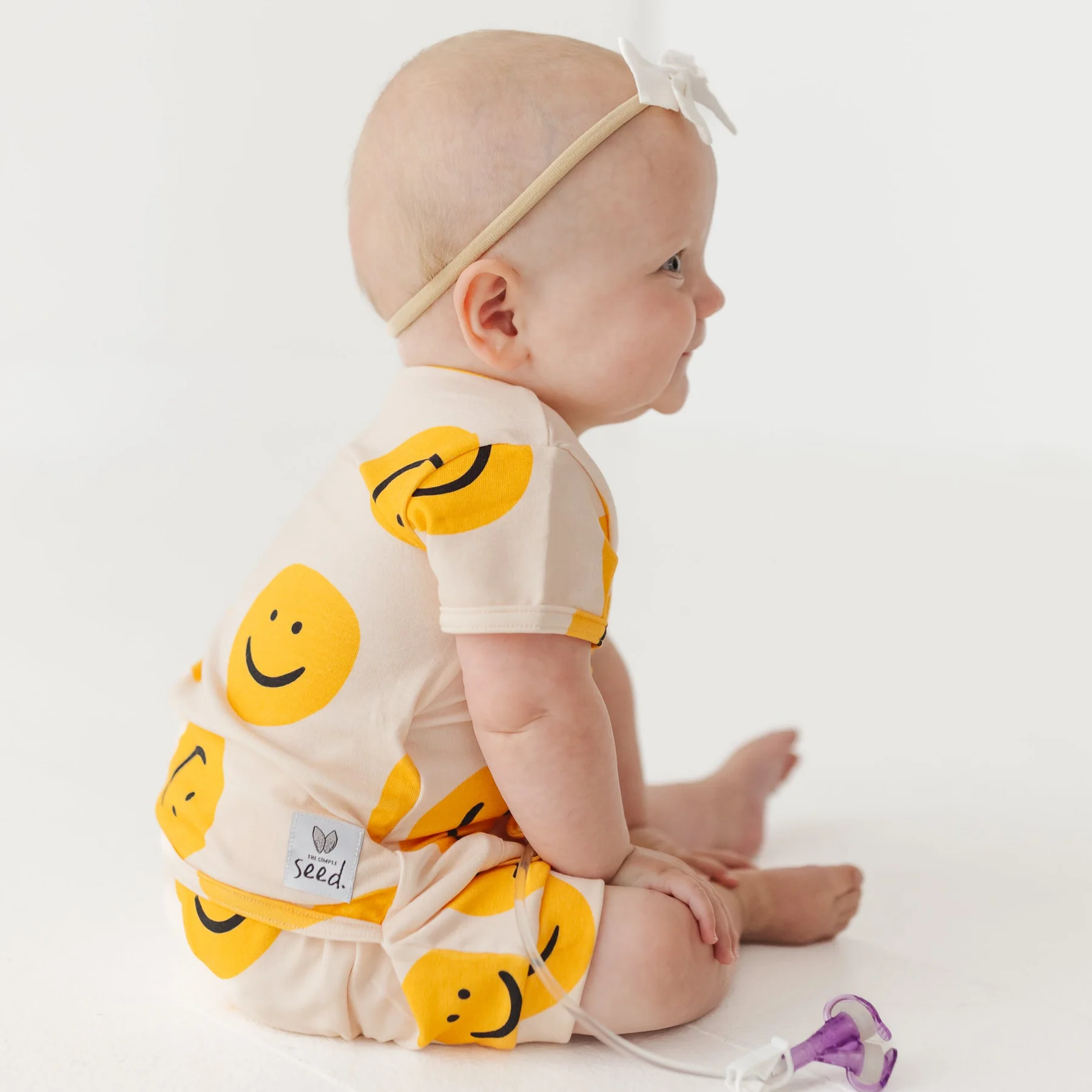 Baby wears smiley face romper